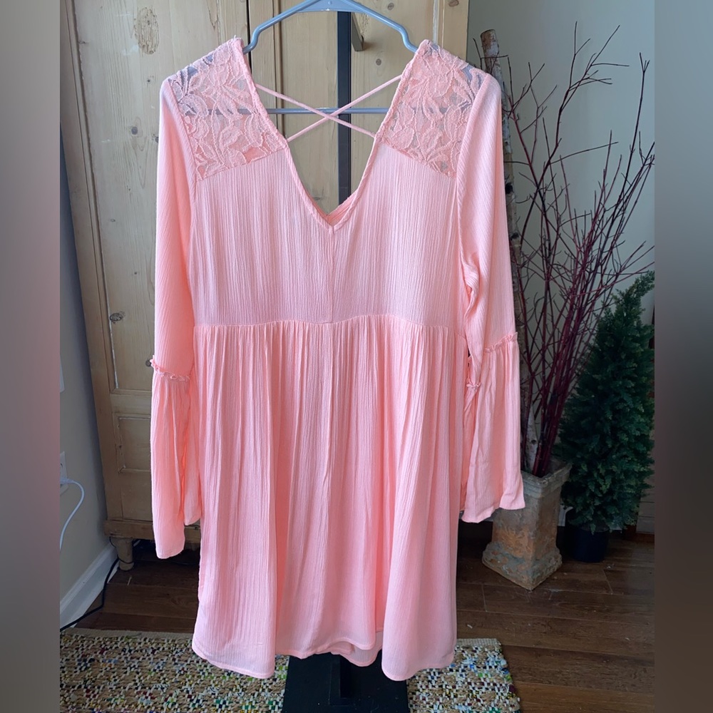 Women’s pink flowy dress with wide sleeves and lace on top.